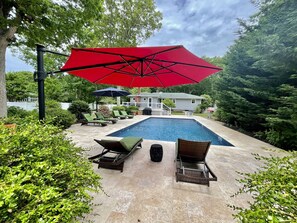A swimming pool with lounge chairs and a red umbrella. - Beach, Pool, Wine, Shopping! (Mattituck)