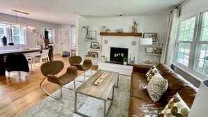 Un salon moderne doté d’une cheminée, d’un coin repas et d’une cuisine.