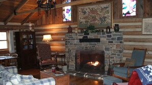 A cozy log cabin interior with a stone fireplace, wooden furniture, and a stained glass window. - It's a place that attracts happiness. (Lexington)