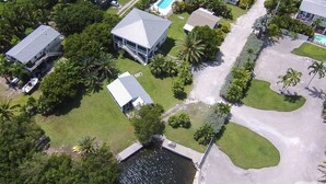 An aerial view of a residential area with houses, a swimming pool, and a small dock. - Cudjoe Cottages, swimming pool, just 20 miles from Key West (Cudjoe Key)