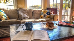 Ein gemütliches Wohnzimmer mit einer Couch, einem Couchtisch und einem offenen Buch.