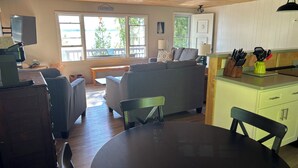 Un salon confortable avec un canapé, une table à manger et une cuisine équipée d’un évier et d’ustensiles.