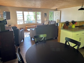 A cozy living area with a sofa, a dining table, and a kitchen with a sink and utensils.