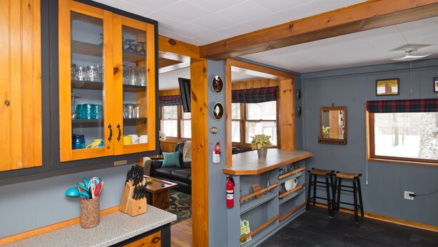 Una cocina con armarios de madera, una encimera y una zona de bar con taburetes.