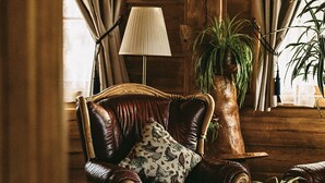 A cozy room with a leather armchair, a wooden coffee table, and a lamp.