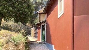 A red building with a green door and a small balcony.