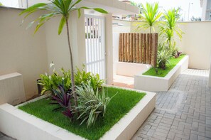 Un espace extérieur aménagé avec des jardinières, une clôture en bois et un chemin pavé.