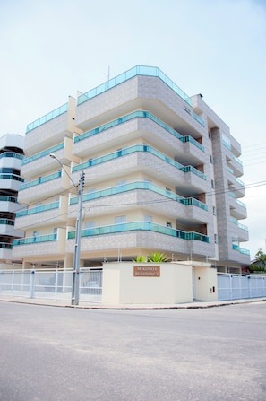 Een meerhoog appartementencomplex met balkons en een hekwerk.