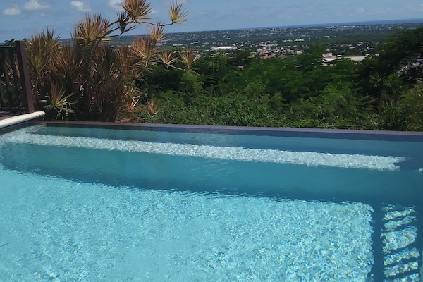 An infinity edge pool overlooks the Barbados countryside.