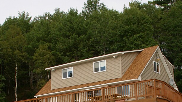 A house with a deck, a lifebuoy, and a pond in the foreground. - Exclusive Lakehouse  (Jefferson)