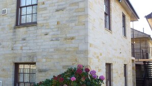 A stone building with multiple windows and a balcony. - API Leisure & Lifestyle Battery Point (Battery Point)