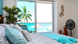 A bedroom with a bed, pillows, a fan, and a view of the ocean. - Paradise Perfected! Your Exclusive Beachfront Escape in Bucerías. (Bucerias)