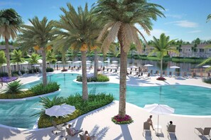 A resort pool area with palm trees, lounge chairs, and umbrellas.