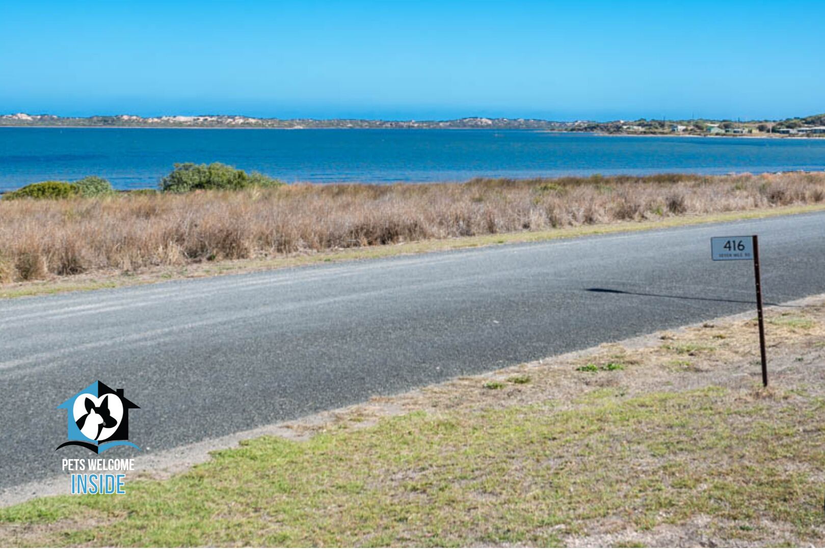 A road with a sign reading "416" and a logo for "Pets Welcome Inside" on the left.