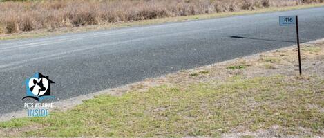 A road with a sign reading "416" and a logo for "Pets Welcome Inside" on the left.