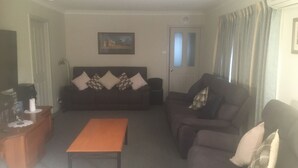 A living room with a sofa, a coffee table, and a painting on the wall.
