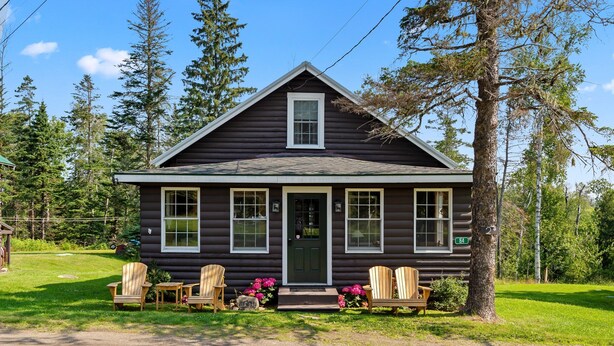 A log cabin with a front porch, two Adirondack chairs, and a bench. - Rangeley Manor 2 | Great Cabin with Shared Access to Rangeley Lake. (Rangeley)