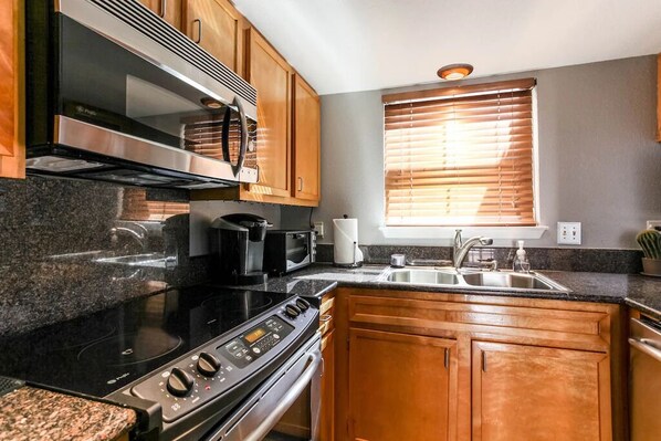 Enjoy cooking in this well-equipped kitchen with a sink, oven, and microwave.