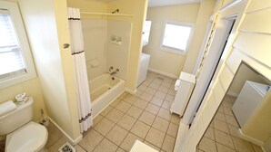 Une salle de bain avec une baignoire, des toilettes et un lavabo.