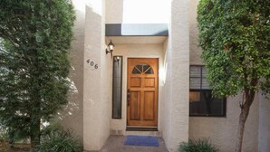 A house with a wooden door, a mailbox, and a number '406' on the wall.