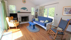 A living room with a fireplace, a sofa, a rocking chair, and a television.