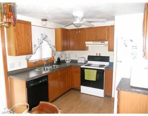Enjoy cooking in this well-equipped kitchen with a stove, dishwasher, and sink.