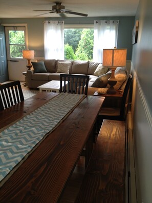Cozy living room with a central dining table, comfortable sofa, and floor lamp.