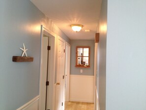 Enter a serene hallway with a starfish decoration, leading to a room with a window and a mirror.