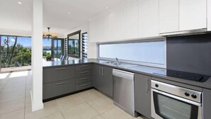 A modern kitchen with grey cabinets, a dishwasher, and an oven.