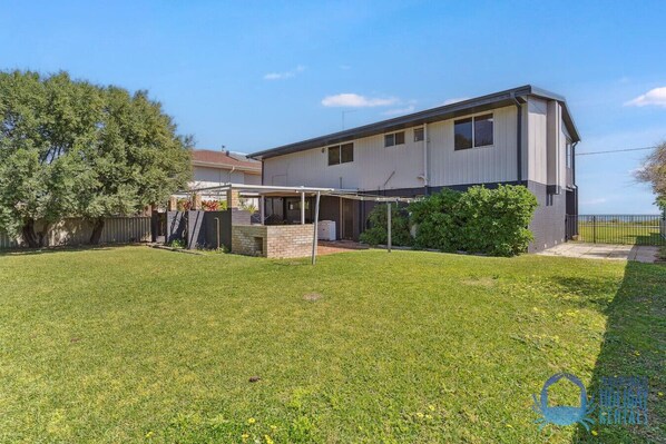 A two-story house with a covered patio and a fenced backyard. - Beachside at Silver Sands (Silver Sands)