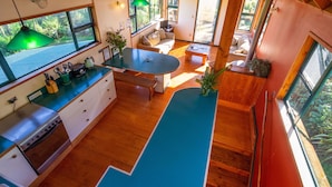 Una cucina moderna con zona pranzo, pavimento in legno e ampie finestre.