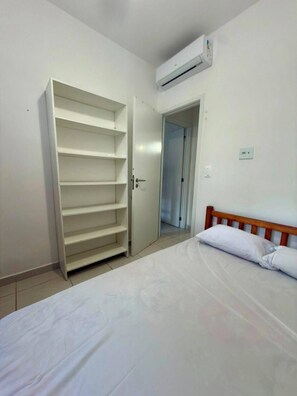 A bedroom with a bed, a wardrobe, and an air conditioning unit. - NEW APARTMENT, COND. HIGH STANDARD ON THE GRANDE BEACH INTEGRATED THE FOREST EXUBERENCE (UBATUBA)