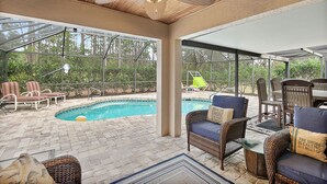 An outdoor patio with a pool, wicker furniture, and a ceiling fan. - Heated Pool - 4BR - Sleeps 10 - Pet Friendly (Palm Coast)