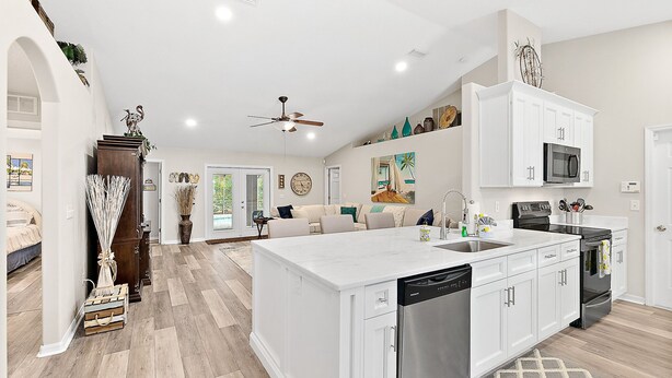A spacious kitchen with white cabinetry, a central island, and a dishwasher. - Heated Pool - 4BR - Sleeps 10 - Pet Friendly (Palm Coast)