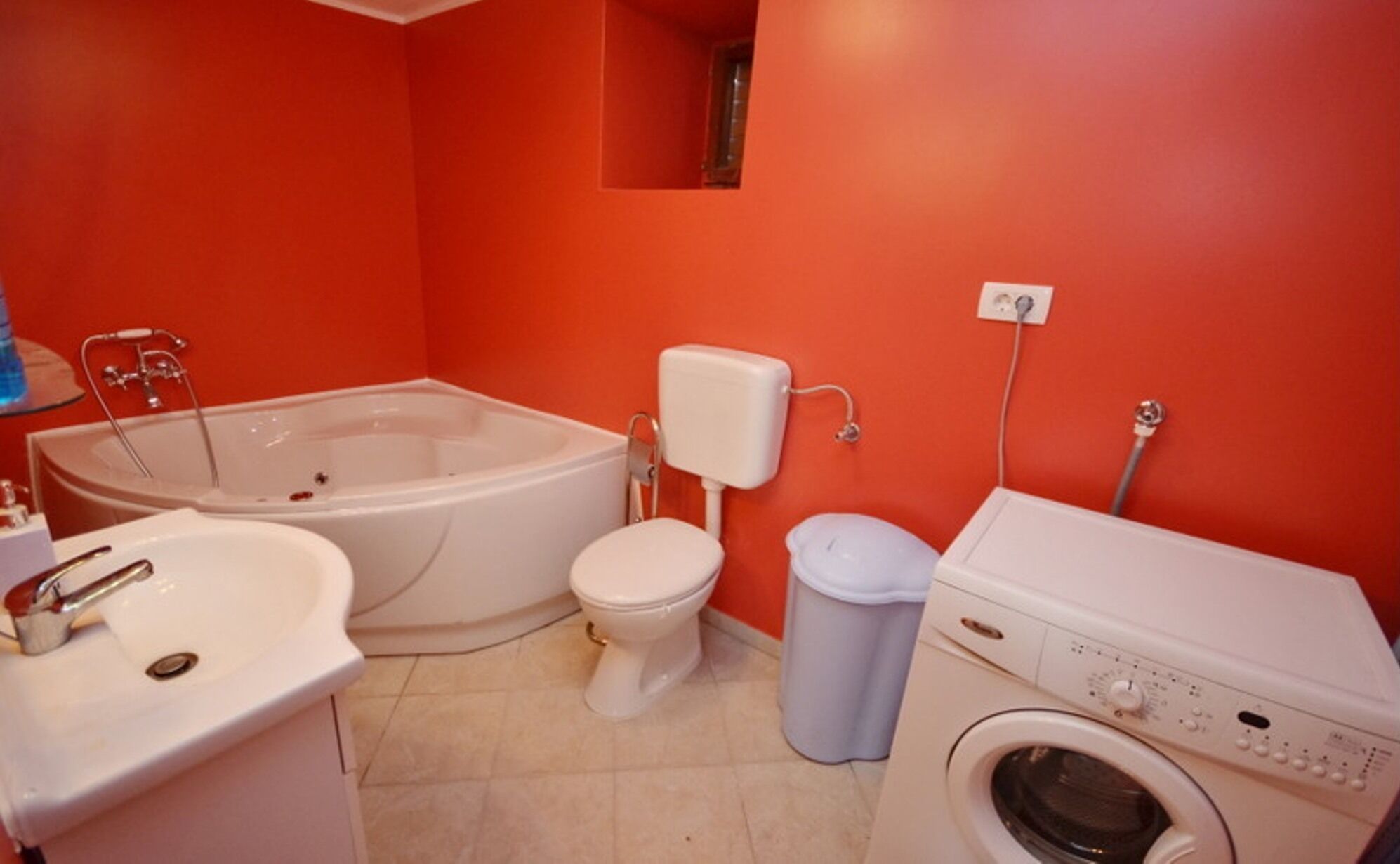 A bathroom with a bathtub, toilet, sink, and washing machine.