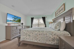A bedroom with a bed, a dresser, a television, and a window with curtains. - Villa Florida Belle - Solana Resort - Luxury Orlando Villa close to Disney (Davenport)