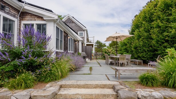 A house with a stone pathway leading to a patio area with outdoor furniture and a barbecue grill. - Katama Luxury - 5+ BR home w/ Heated Pool near the Field Club (Edgartown)