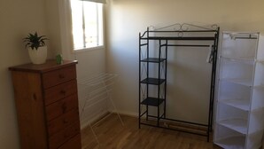 A room with a wooden dresser, a metal shelving unit, and a drying rack. - North Perth Cottage - Close to city (North Perth)