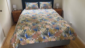 A bedroom with a bed, two nightstands, a window, and a door. - North Perth Cottage - Close to city (North Perth)
