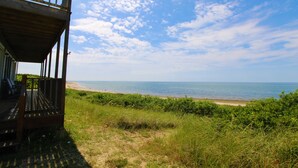 A wooden deck overlooking a beach with a clear sky. - Watch the Sunset from this Bayfront Home! (1349) (Wellfleet)
