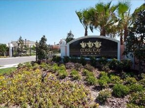 Welcome to Coral Cay Resort & Spa, where lush landscaping surrounds the entrance.