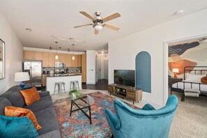 Ein modernes Wohnzimmer mit einer Couch, einem Couchtisch und einem Fernseher.