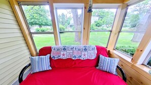 A room with a red bed, two striped pillows, and a quilt with a star pattern.