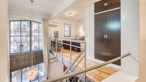 Ein modernes Apartment mit Balkon, Treppe und Blick auf die Stadt.