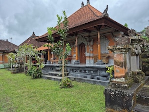 A traditional building with a tiled roof, a wooden door, and a stone staircase leading to the entrance.
