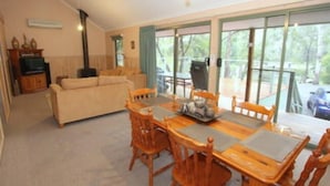 Un comedor con una mesa y sillas de madera, un sofá y un televisor.