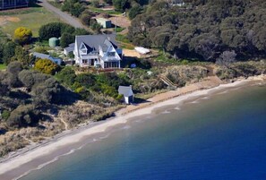 An aerial view of a coastal property with a large house, a beach, and surrounding vegetation. - SALTCOTES BEACH HOUSE TASMANIA (OPOSSUM BAY)