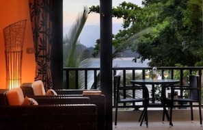 Relax on the balcony with a serene view of the lake and lush surroundings.