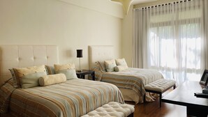 A hotel room with two beds, a bench, a desk, and a star-shaped ceiling light. - Amazing, Luxury condominium on the 18 hole of Dye Fore  Golf Course (La Romana)