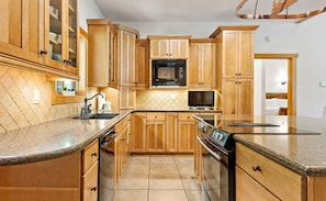 Enjoy cooking in this well-equipped kitchen with a microwave, oven, and large island with a sink.